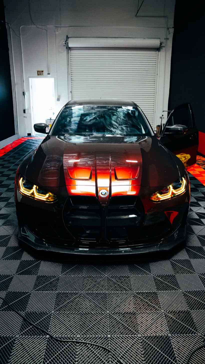 Black BMW M4 with glowing headlights inside the Most Wanted bay