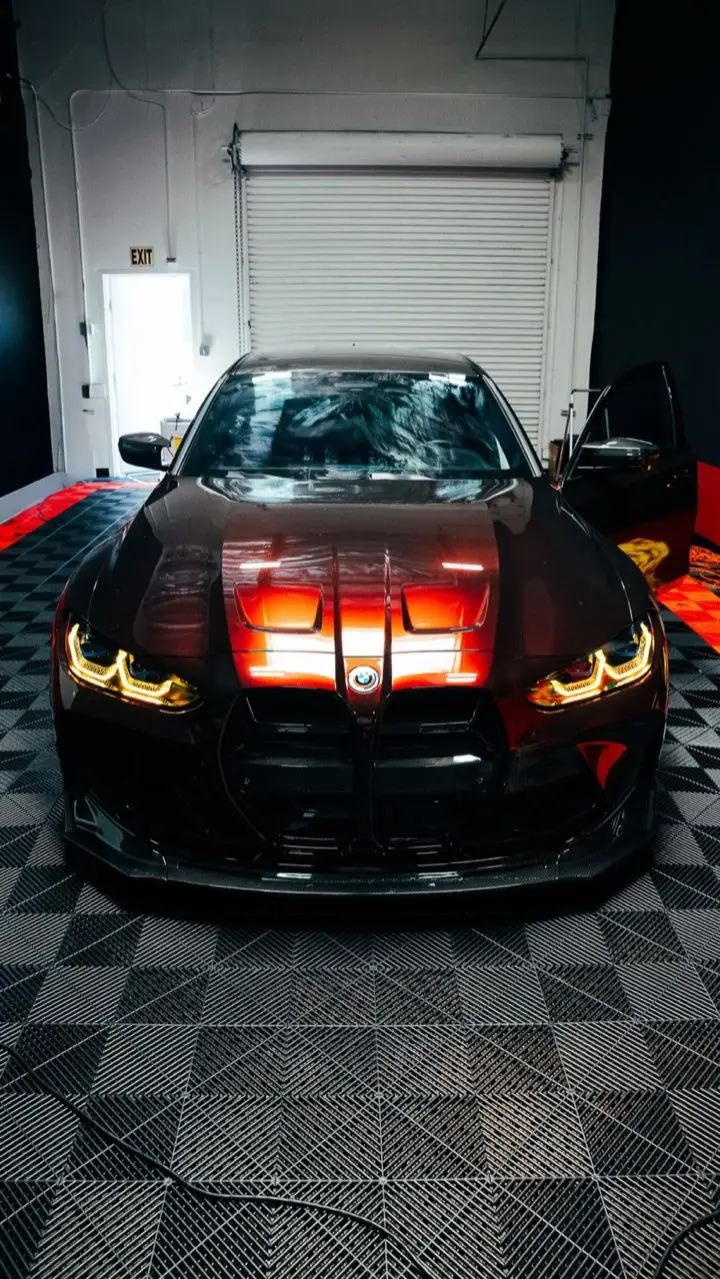 Black BMW M4 with glowing headlights inside the Most Wanted bay