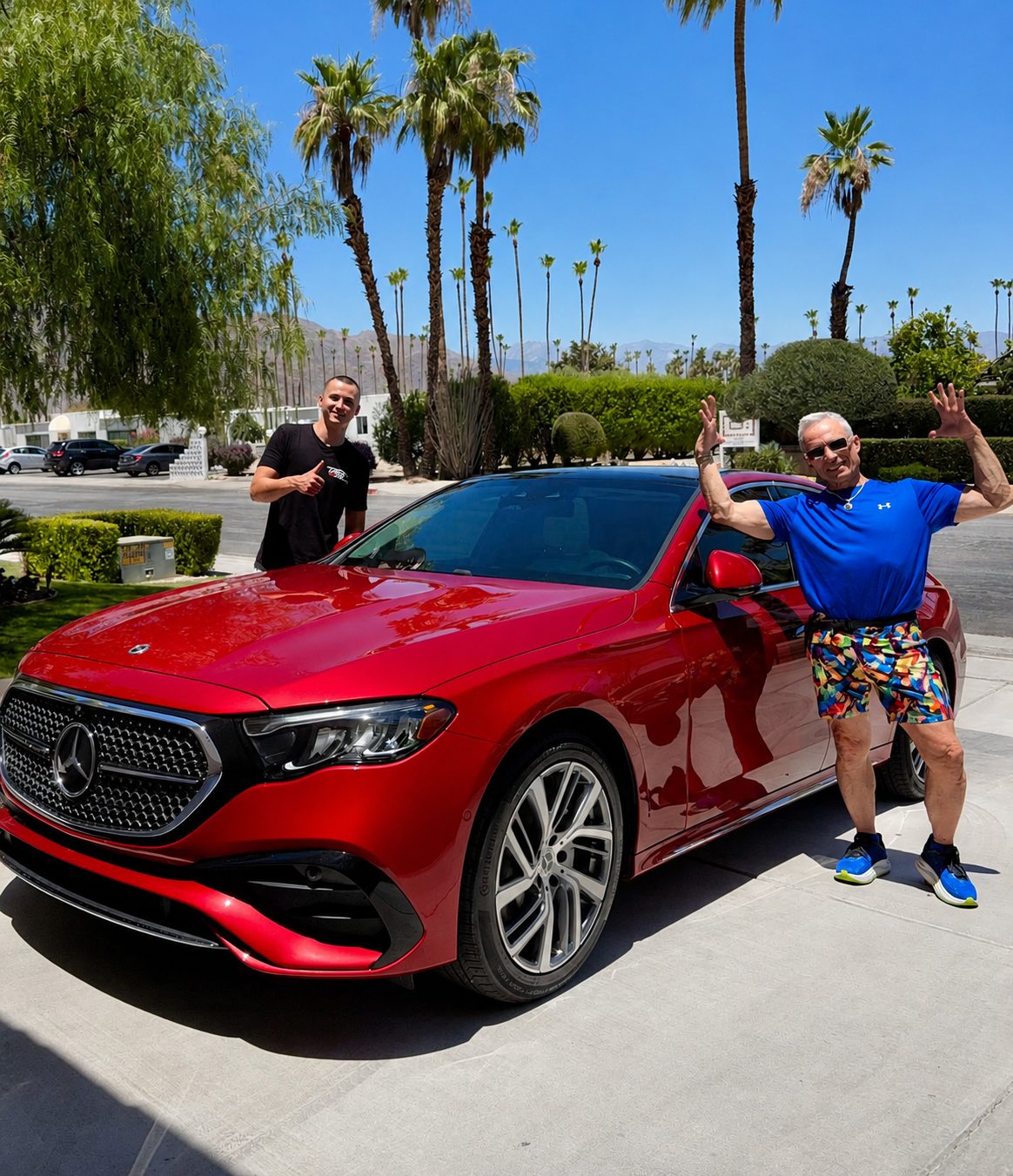 Two happy clients next to a red Mercedes E-Class on pickup day