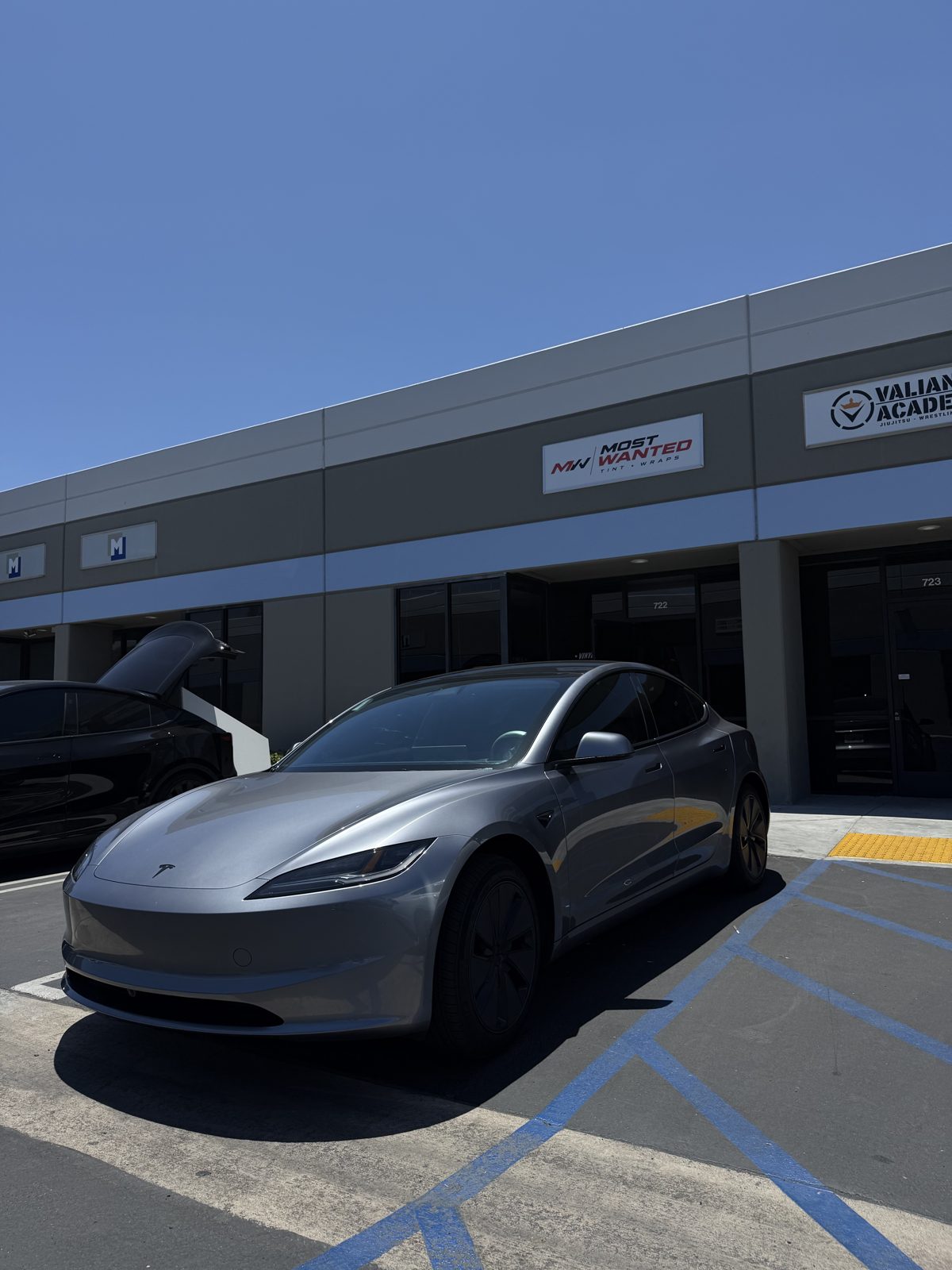 Gray Tesla Model 3 parked outside the bays