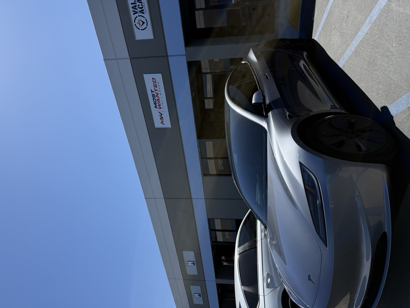 Silver Tesla Model 3 with fresh ceramic tint outside the shop