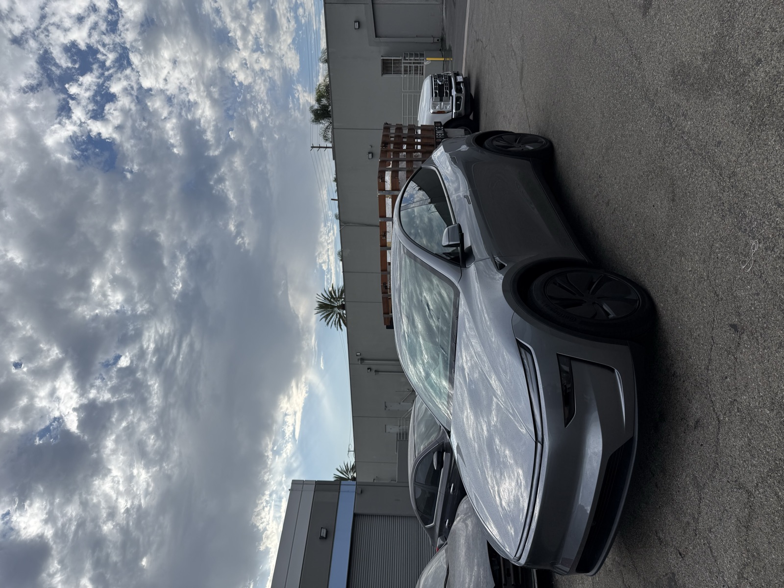 Gray Tesla Model Y under a cloudy sky outside the studio