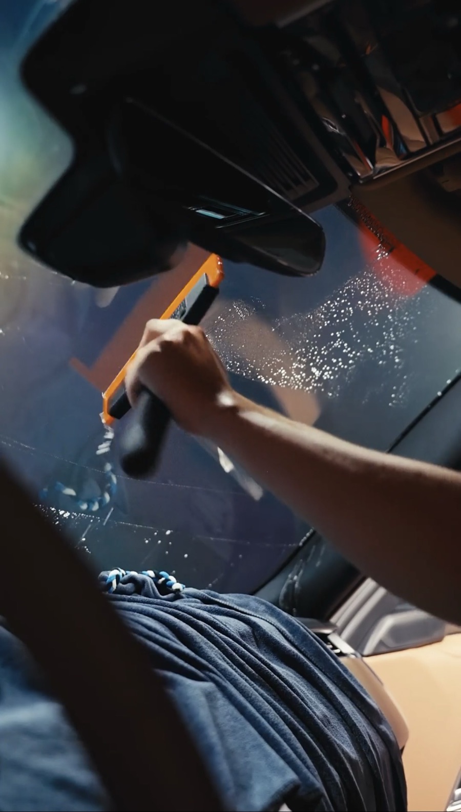 Squeegee working film onto glass during a tint install