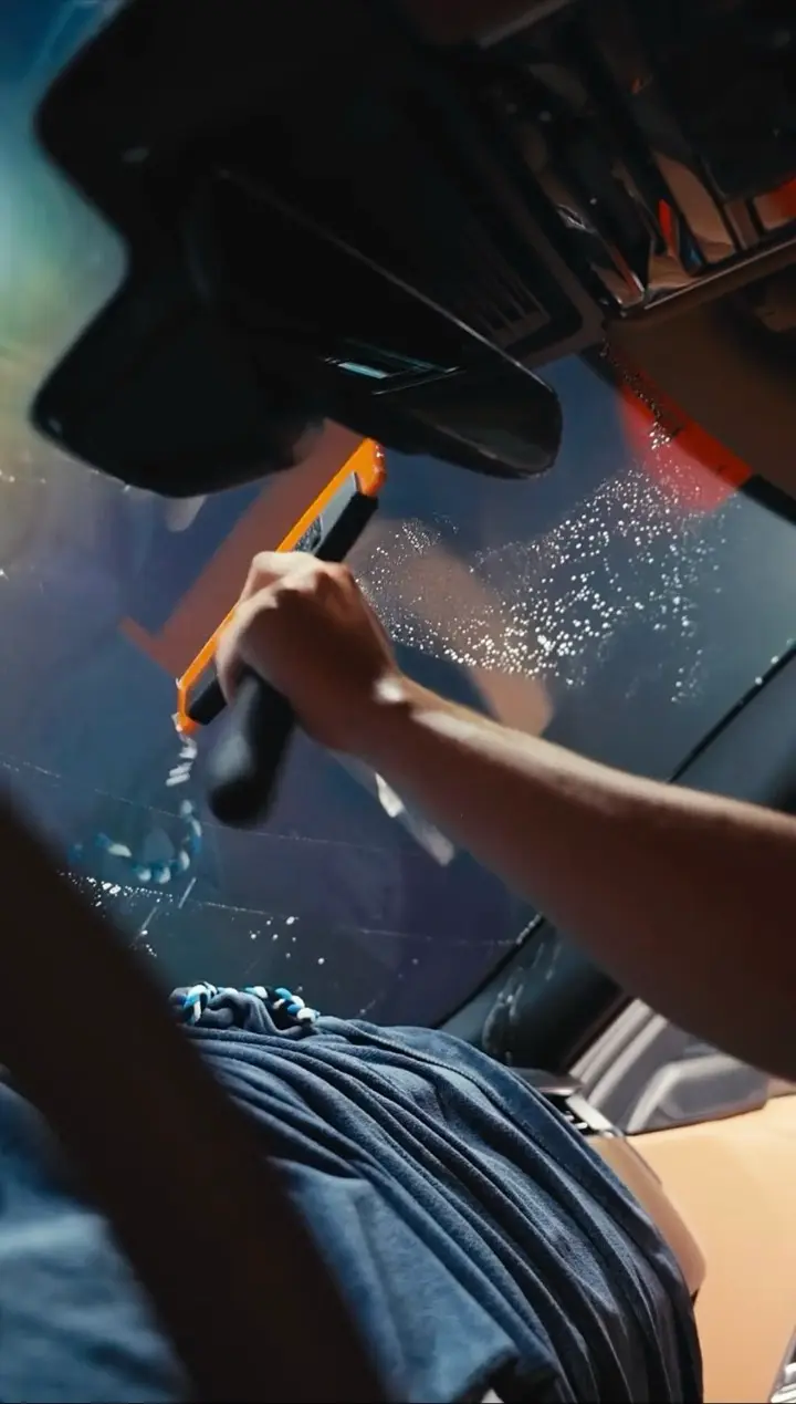 Squeegee working film onto glass during a tint install